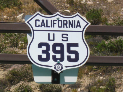 A California US 395 sign attached to a brown metal pole.